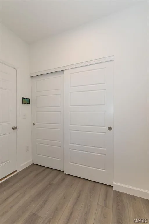 Unfurnished bedroom featuring light wood-type flooring and a closet — 717 Southerland Drive, O'Fallon, MO 63368