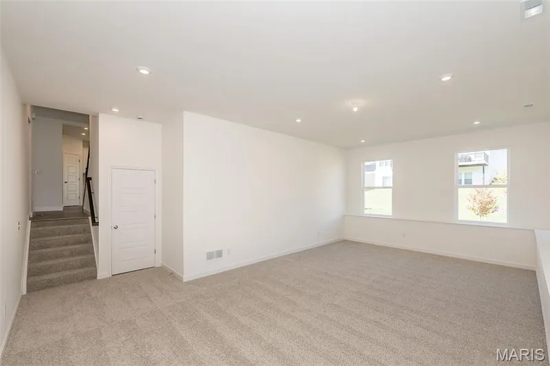 Unfurnished room with stairs, light carpet, and recessed lighting — 717 Southerland Drive, O'Fallon, MO 63368